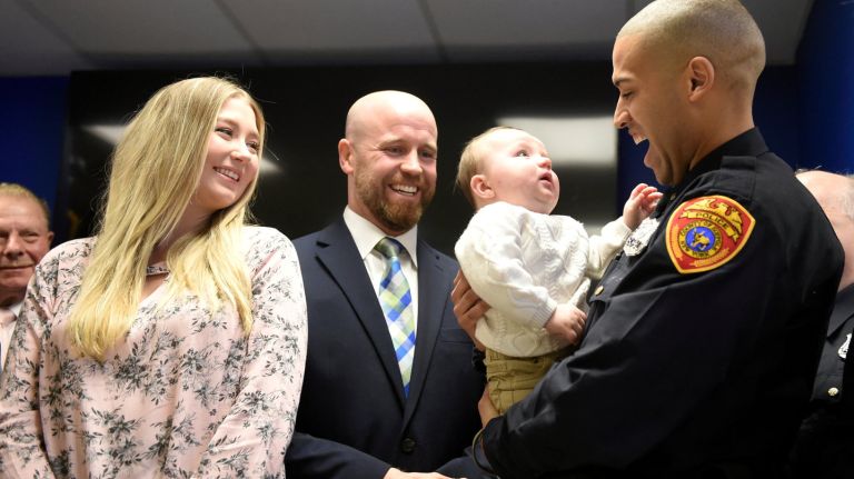Officer Jon-Erik Negron, holds baby Bryce, as his parents, Mike and Jane Pappalardo, watch on Thursday, Jan. 25, 2018. Photo Credit: James Carbone